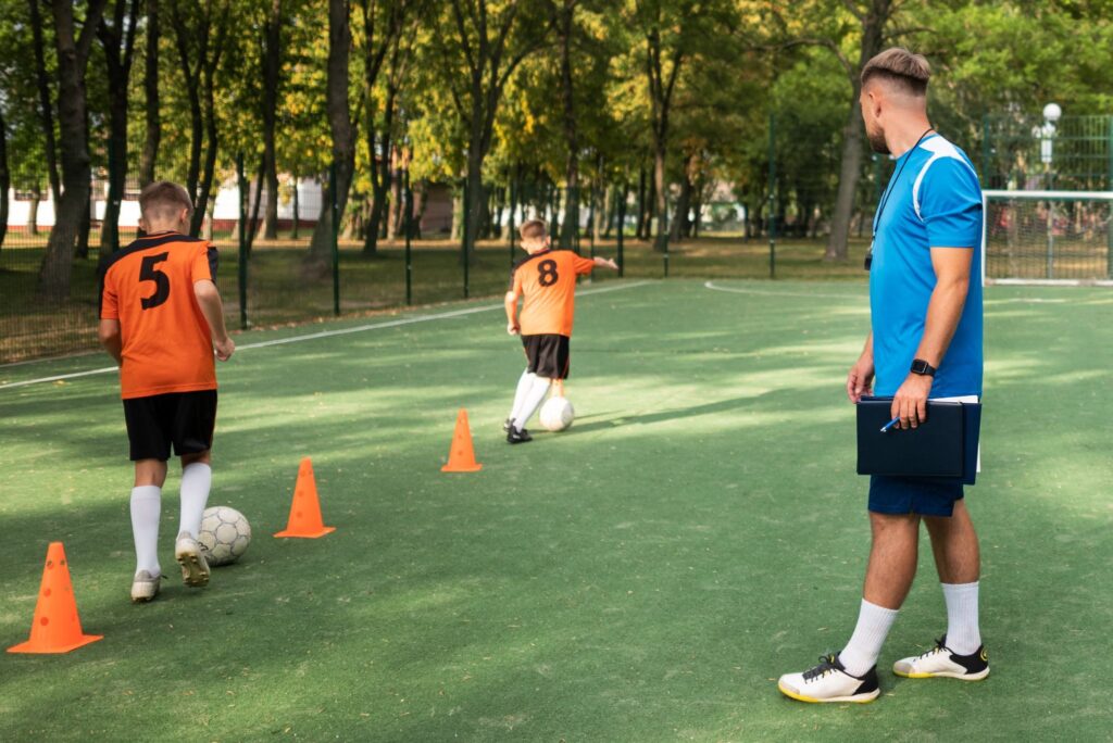 Treinador de futebol ensinando seus alunos.