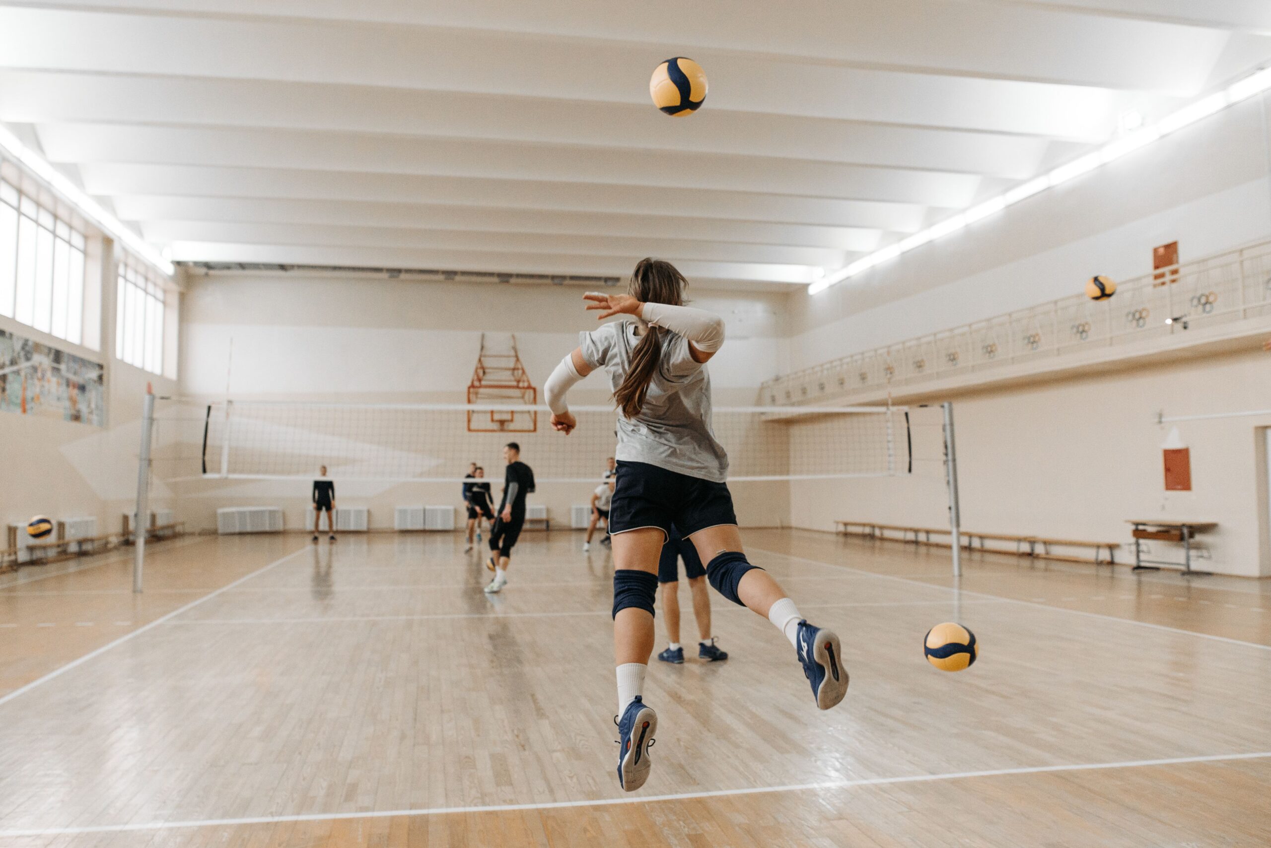 Uma partida de voleibol em um ginásio poliesportivo.