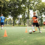 criança fazendo um treino de futebol.