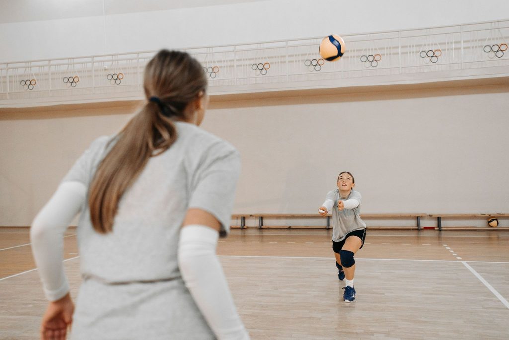 Atletas realizando exercícios e fundamentos de vôlei.