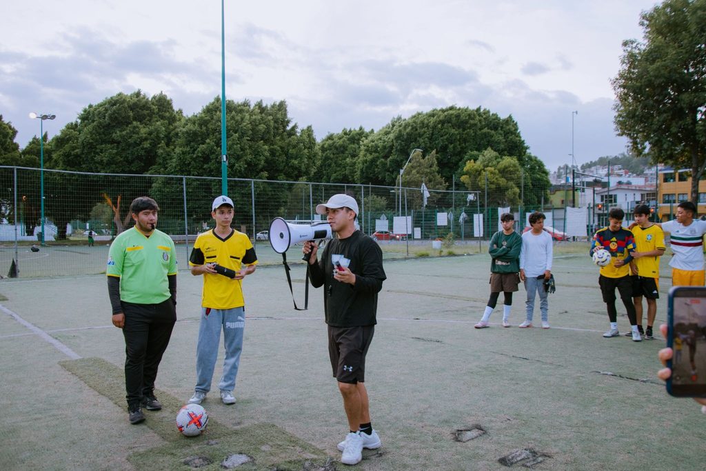 Crianças durante um treino de futebol com orientação do professor.