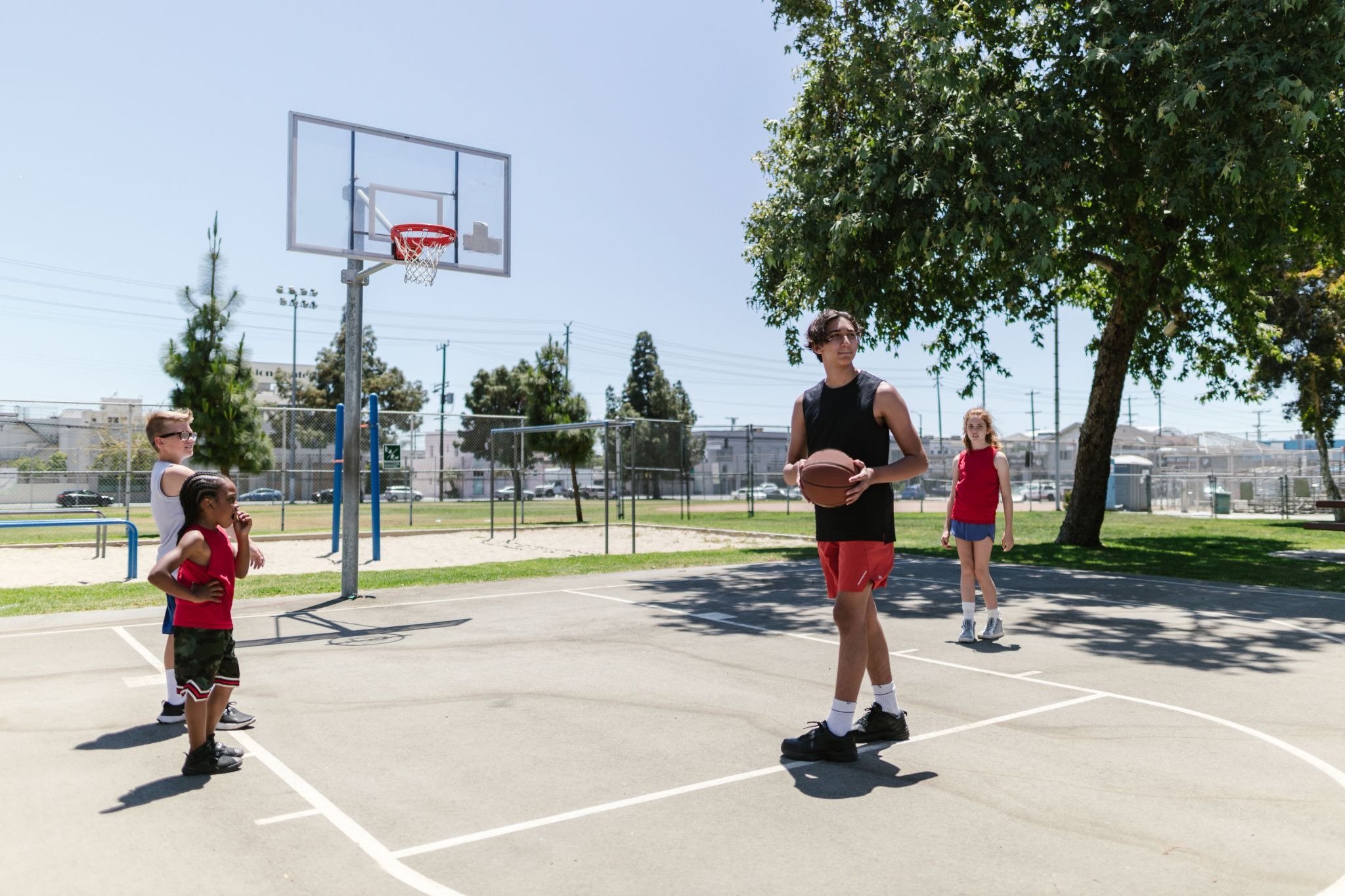 Crianças praticando basquete em grupo.